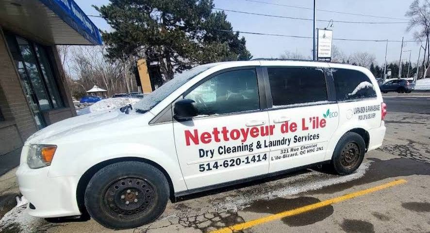 White minivan advertising Nettoyeur de l’île dry cleaning and laundry services in a snowy parking lot.